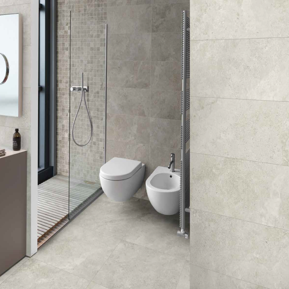 Modern bathroom with tiled walls and floor, featuring a toilet and sink.